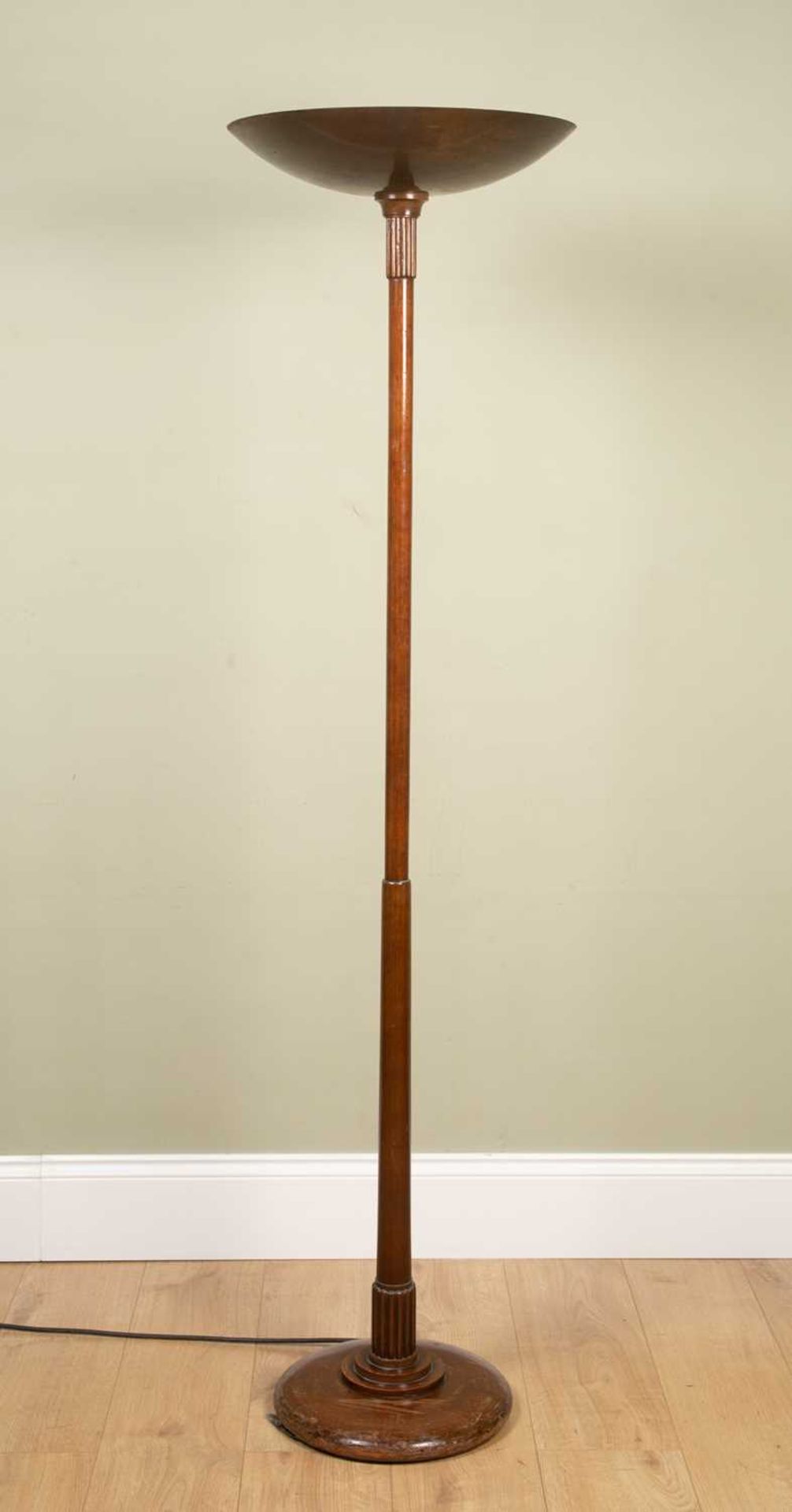 An Art Deco mahogany and brass floor standing uplighter with dish top on a slender column support