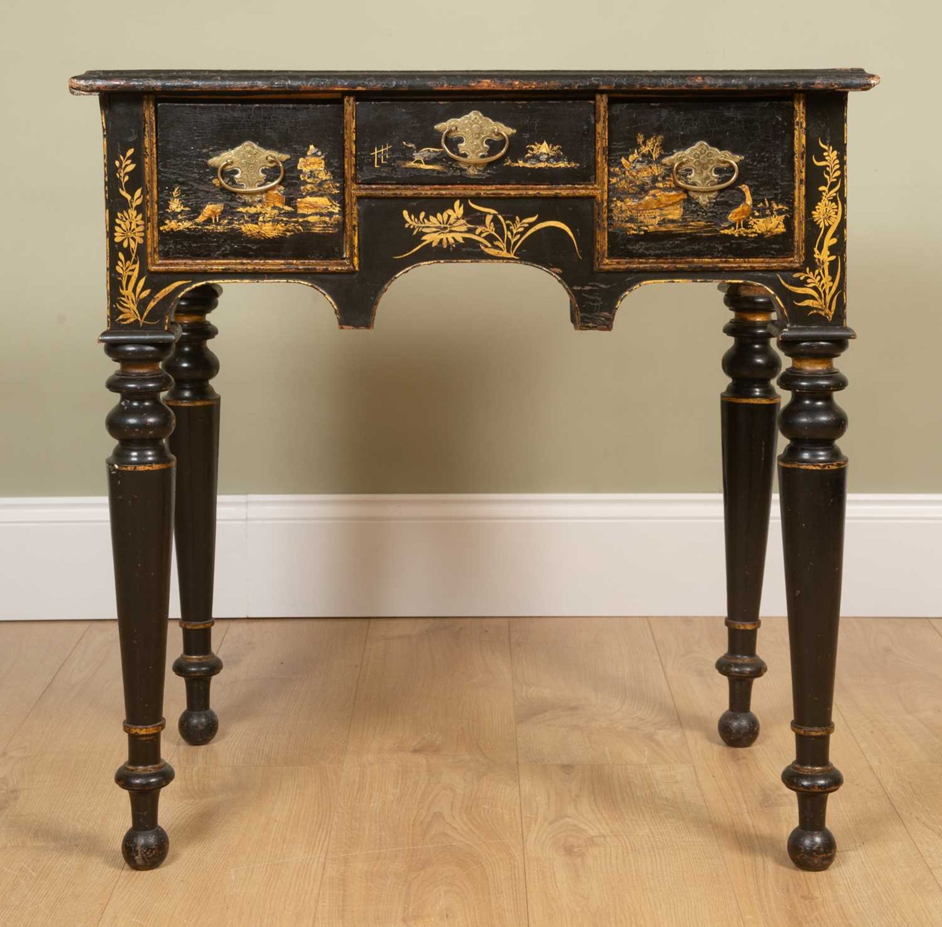 An early 18th century and later black lacquered chinoiserie decorated lowboy, with village and