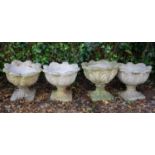 A set of four cast reconstituted stone garden planters, the bowls with acanthus leaf moulding, on