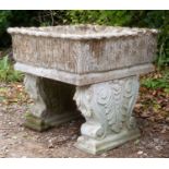 A cast reconstituted stone square planter, with acanthus leaf decoration, on scrolling supports,