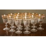 Two sets of six cut glass wine glasses, the orange rims with engraved foliate decoration, facetted