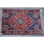 A Heriz rug with blue and red ground decorated with stylised diamond motif within a blue and white