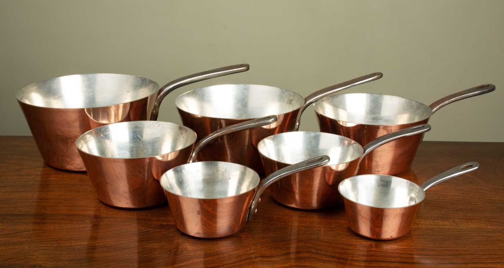 A graduated set of seven copper saucepans by Villedieu, the largest saucepan 22cm diameter; together