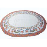 A large European hand woven needlepoint oval carpet with cream ground and orange border, 575cm x