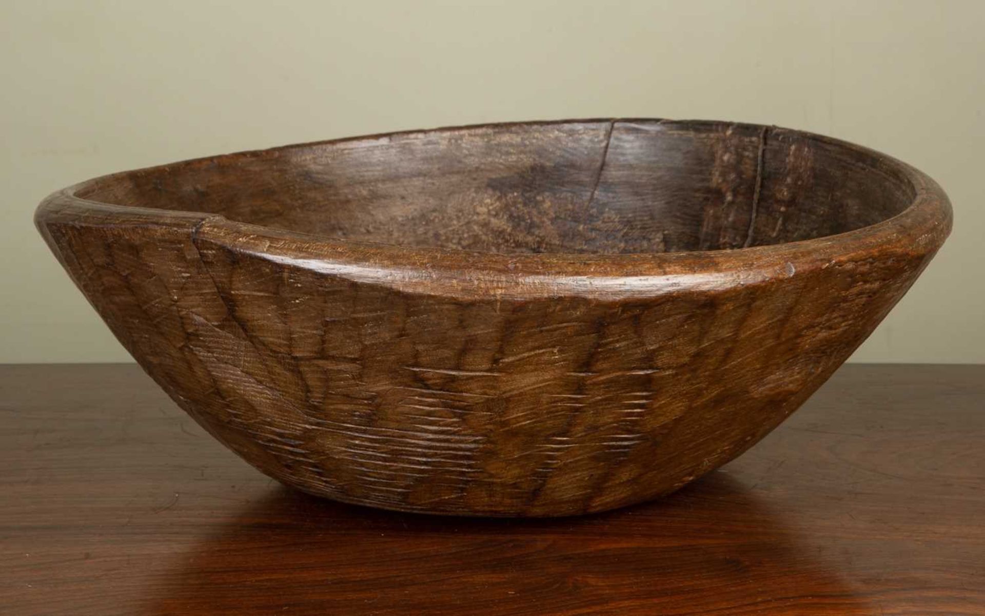 An antique turned sycamore dairy bowl, with old splits and old wrought iron patch, 42cm diameterThis