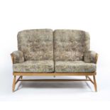 Ercol light elm sofa, with floral upholstered cushions, with Ercol circular label to the