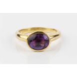 An amethyst and diamond dress ring, the oval buff-top amethyst in closed-back collet setting,