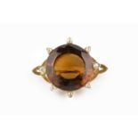 A citrine and diamond brooch, the circular mixed-cut citrine bordered by old-cut diamonds, between
