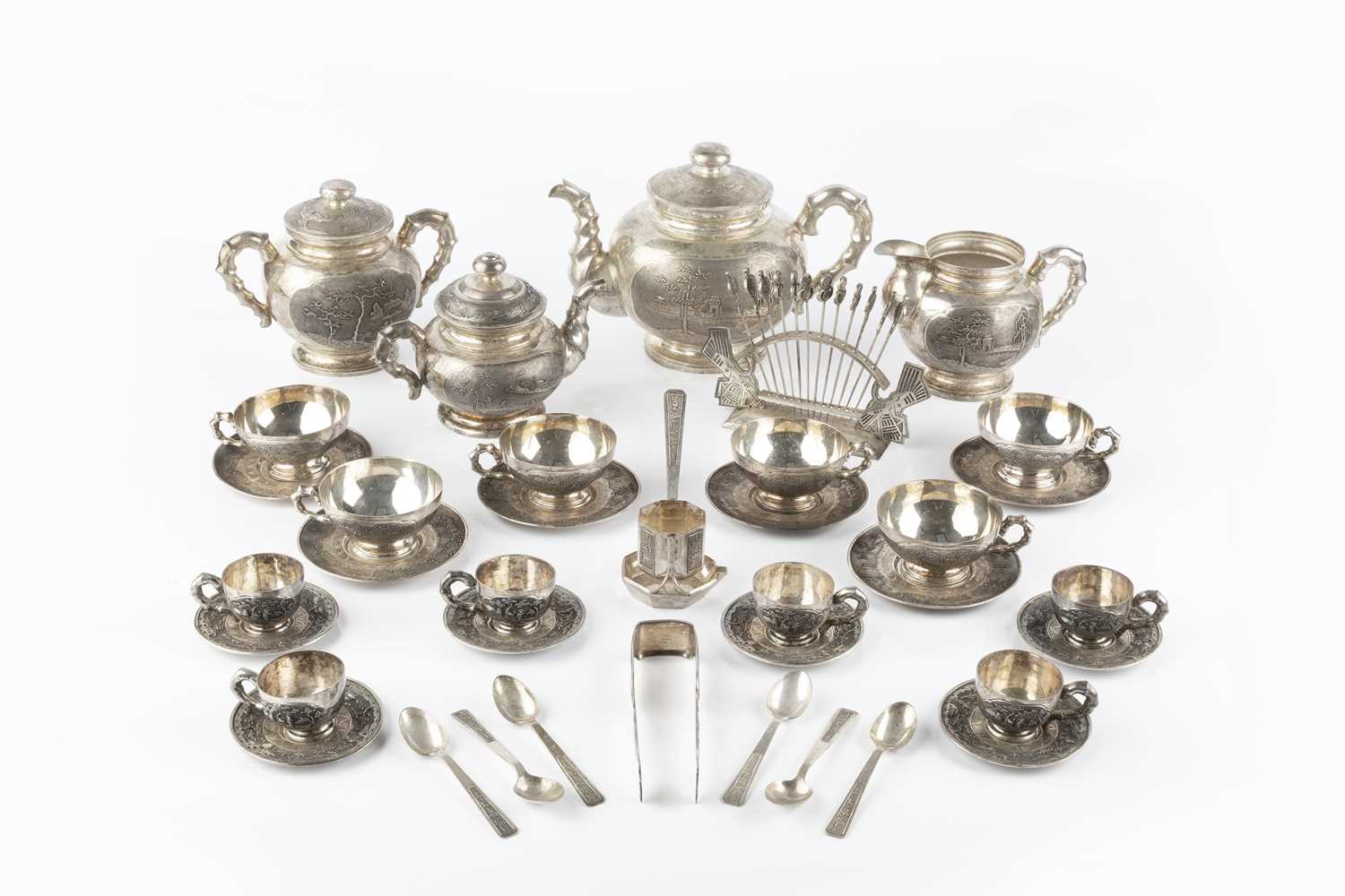 An extensive Vietnamese silver tea service, relief decorated and engraved with landscape