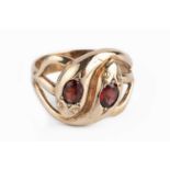 A garnet set serpent ring, designed as two entwined serpents, each highlighted with an oval mixed-