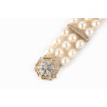 A cultured pearl and diamond bracelet, comprising three rows of baroque cultured pearls, spaced by