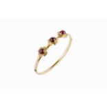 A Victorian garnet set bangle, of hinged oval hollow form, applied with a trio of foliate scroll