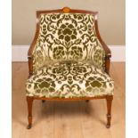 An Edwardian tub back low chair with green and white upholstery, on tapering supports and castors,