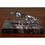 A Jaguar ashtray, the white metal mascot mounted on a marble base, 18cm wide x 15.5cm deep x 7cm