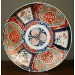 A 19th century Japanese charger, with central stylised flower medallion surrounded by panels of