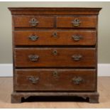A small sized Georgian oak chest of two short and three long drawers standing on bracket feet,