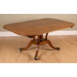 A Regency mahogany tilt top dining table with cross banded top, pillared supports, the sabre legs