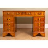 A Georgian-style pedestal desk with a tooled leather top, with nine drawers about the knee and