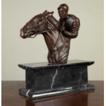 A bronze head and shoulders of a mounted jockey, on a marble base, 31cm wide x 13cm deep x 39cm