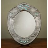 An Art Nouveau pewter dressing table mirror with cut out floral decoration revealing blue enamel