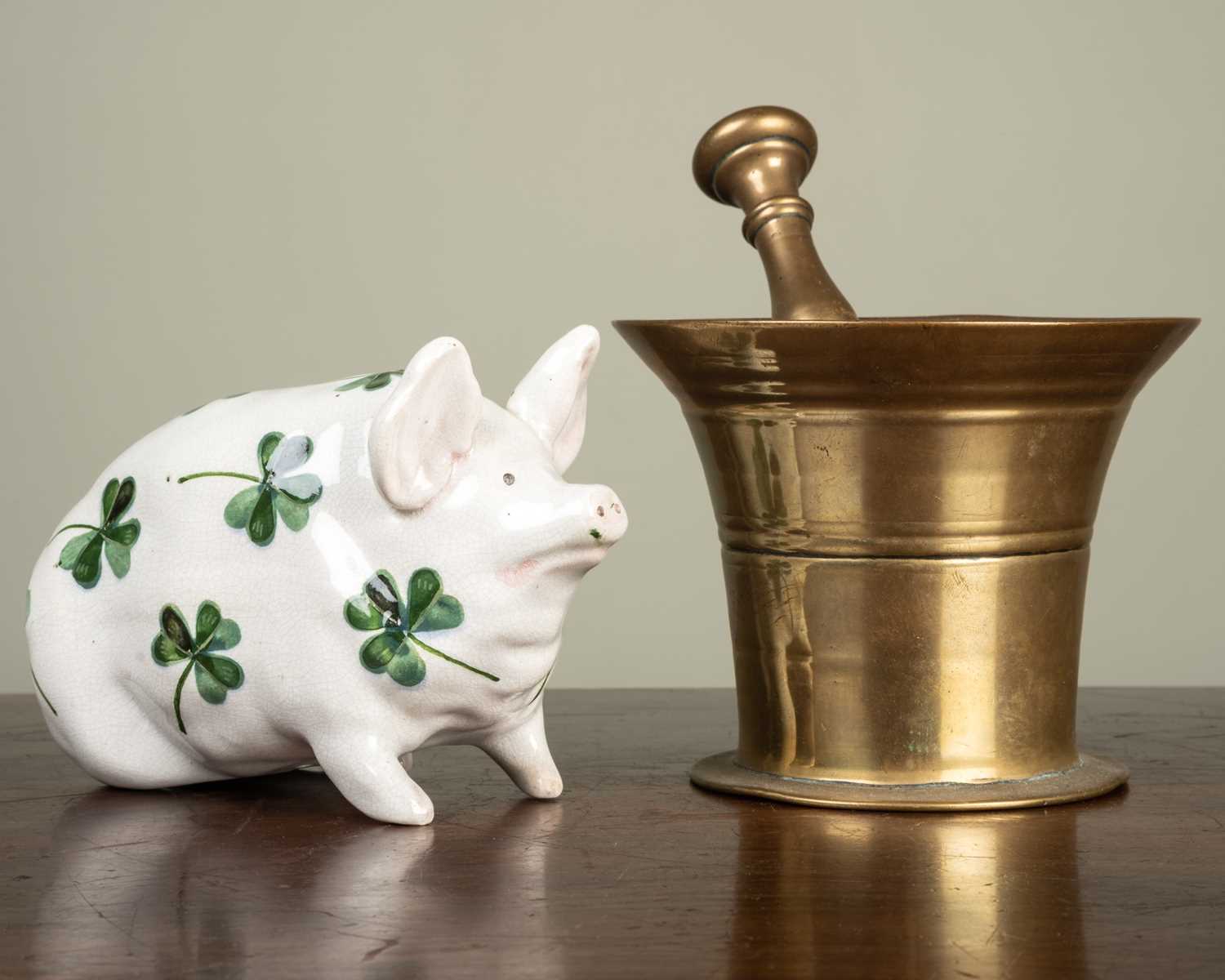 A Wemyss pig and an antique brass pestle and mortar stamped 'HH' beneath, the pig marked with a