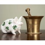 A Wemyss pig and an antique brass pestle and mortar stamped 'HH' beneath, the pig marked with a