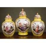 A garniture of three Dresden yellow ground ovoid vases and covers decorated to one side with