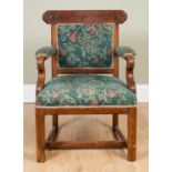 A Victorian Gothic revival oak framed open armchair with an upholstered back, arms and seat,