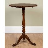 A mahogany tripod table with serpentine top, turned support and carved scrolling feet, 49cm diameter