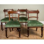 A set of four Victorian mahogany bar backed dining chairs with overstuffed upholstered seats, turned