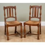 A pair of early 20th century Heals style limed oak chairs with rush seats and turned supports,