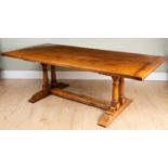 An oak refectory-style dining table, with plank top on double columned supports and trestle base,
