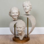 A Kay Theakston sculpture of three childrens heads, composite, mounted on brass posts and a wooden