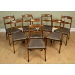 A set of eight Regency style rosewood and brass inlaid dining chairs with upholstered inset seats