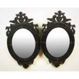 A pair of modern black glass wall mirrors of Venetian style, 40cm wide x 70cm high