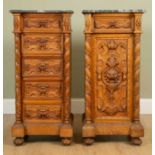 A pair of continental walnut vertical cabinets/chests, each with marble tops and decorative carving,