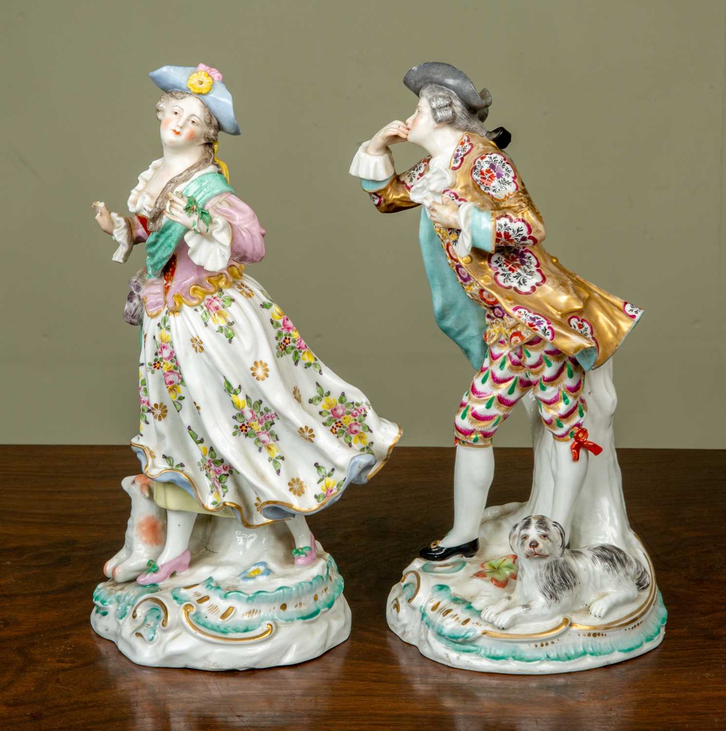 A pair of antique figurines depicting a gentleman and his belle, the gentleman with a dog resting at - Image 2 of 5