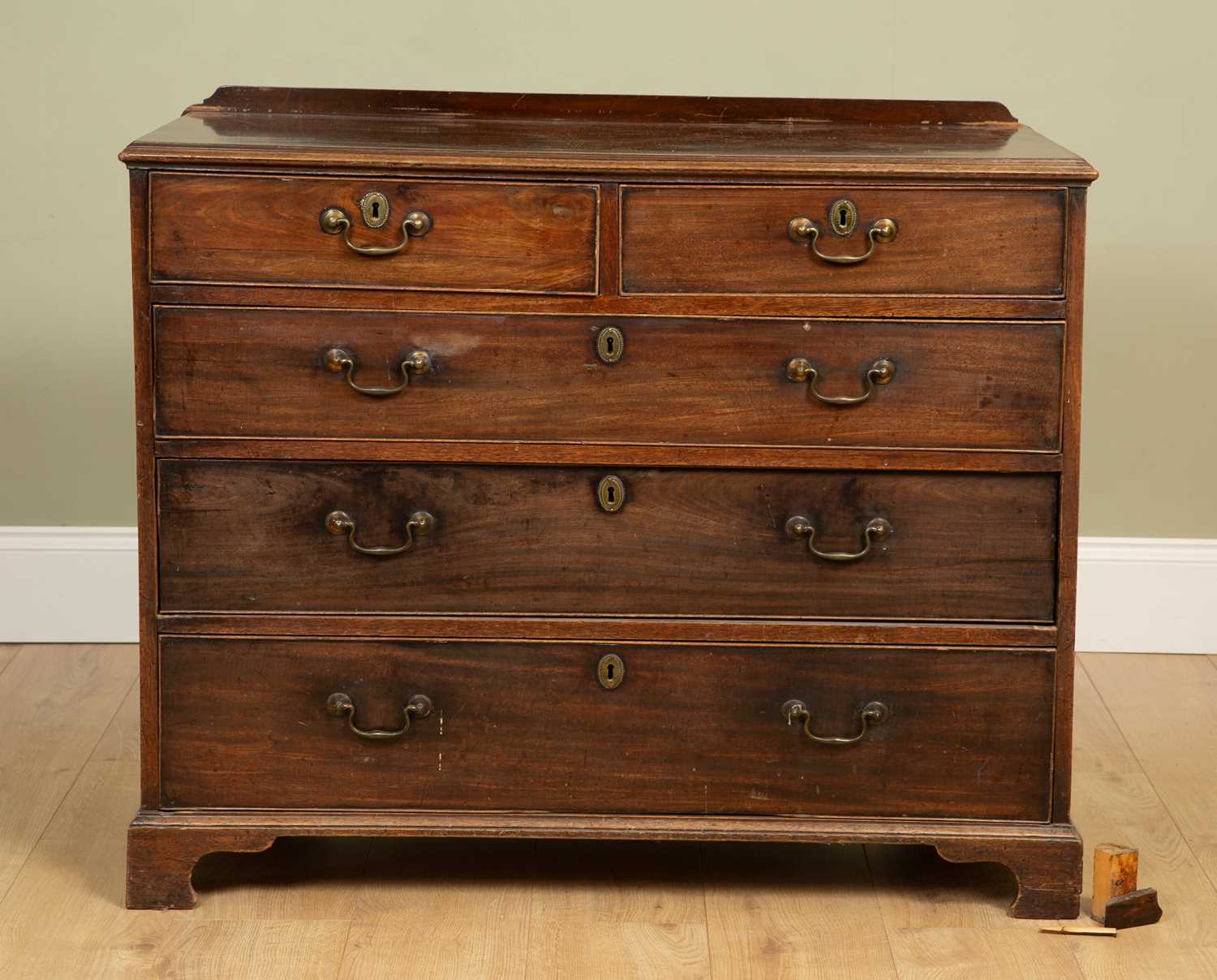 A George III mahogany chest of two short and three long drawers, with brass swan neck handles and