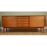 A mid to late 20th century teak sideboard with a central heat plate, two sliding doors and four