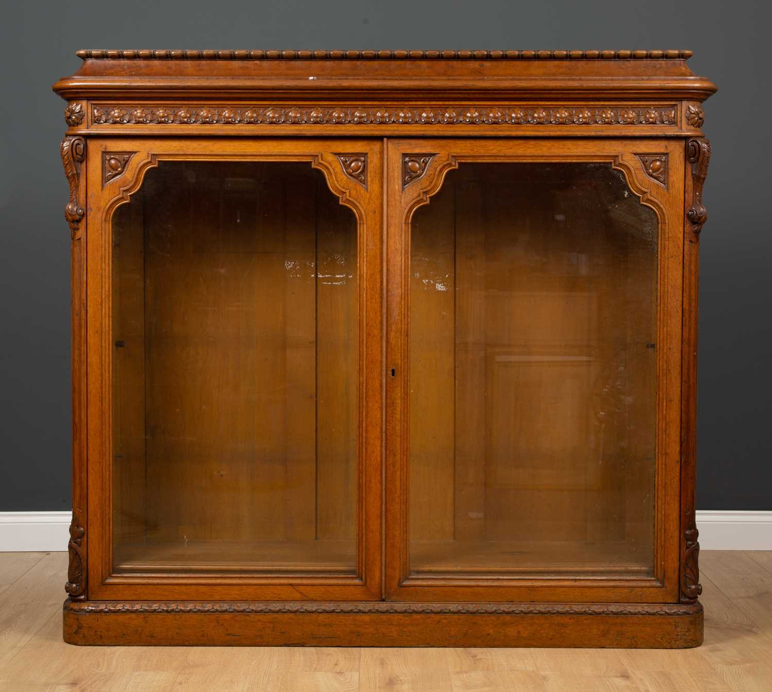 A Victorian oak bookcase with twin glazed doors, two adjustable shelves and a plinth base, 152cm