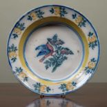 An antique French faience charger with polychrome decoration, 34cm diameterChips and marks to the