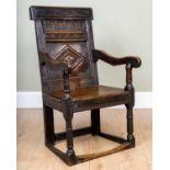 An antique oak panelled armchair, 58cm wide x 50cm deep x 43cm high at the seat and 103cm high at