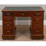 An Edwardian mahogany pedestal desk with a green leather inset top and nine drawers, 107cm wide x