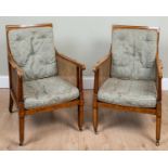 A pair of 19th century mahogany Bergere library armchairs with cross banded decoration and reeded