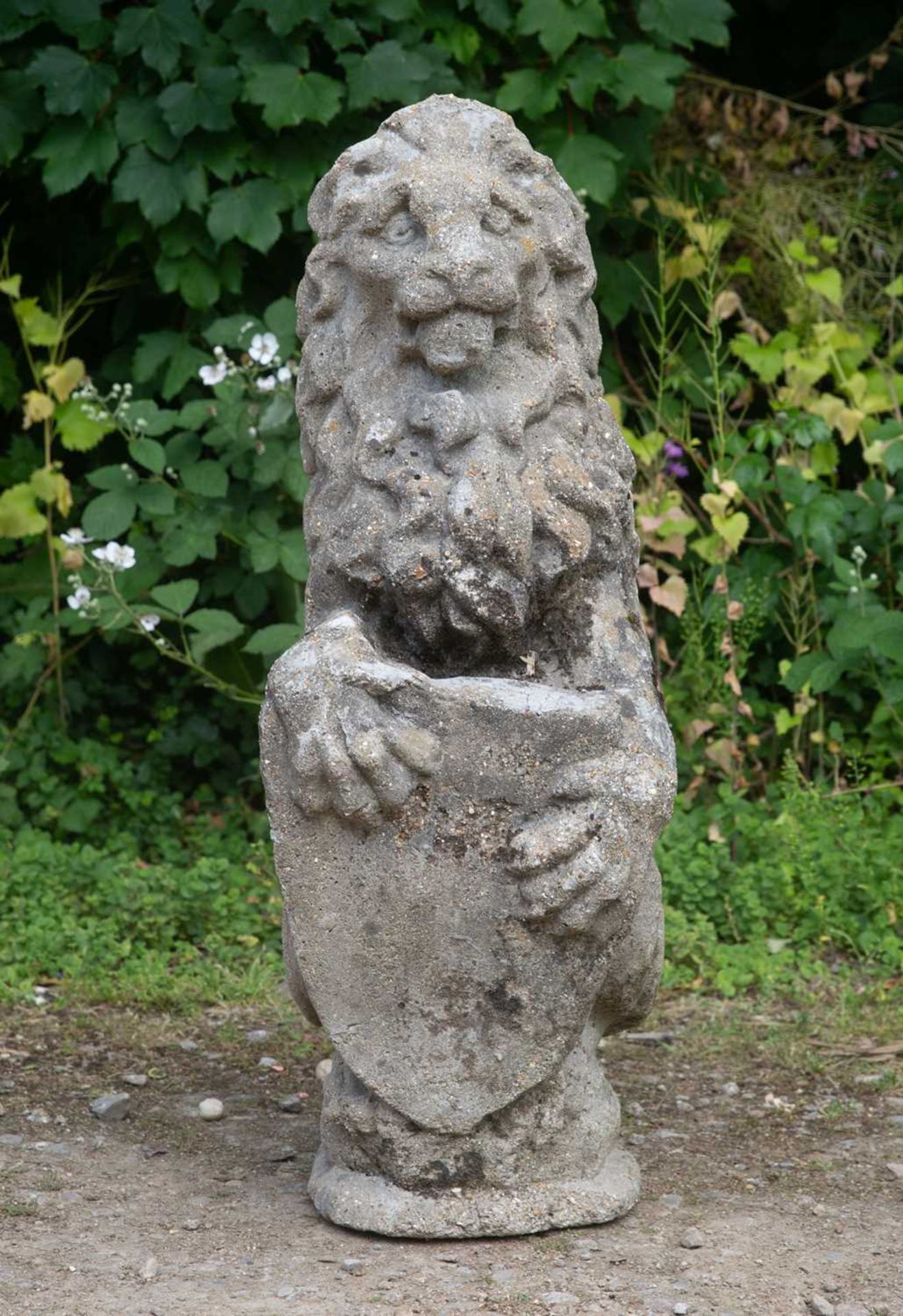 An old cast reconstituted stone lion supporting a shield, 28cm wide x 88cm highSome minor signs of