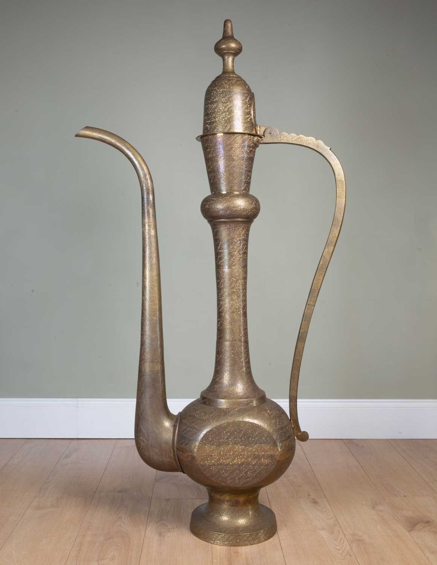 A large decorative Oriental brass display dallah coffee pot with floral chased and engraved