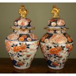 A pair of 18th century Japanese vases and covers of inverted baluster form and decorated in Imari