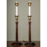A pair of George III-style brass and mahogany table lamps with fluted stems and circular spreading