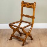 A Victorian oak side chair in the manner of Pugin with pegged carved bar back and X frame supports