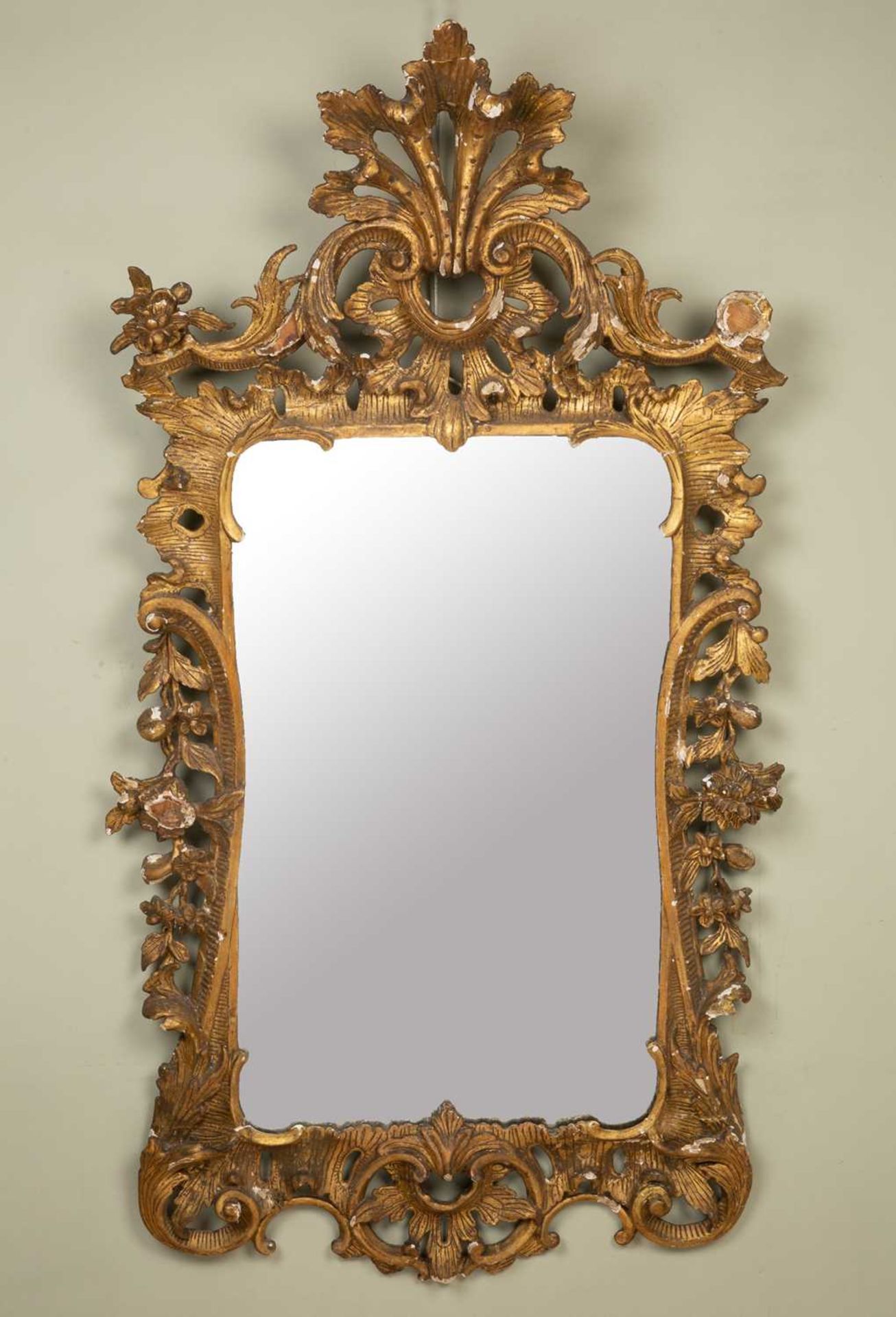 An 18th century carved giltwood pier glass or wall mirror with rocaille scroll crest and